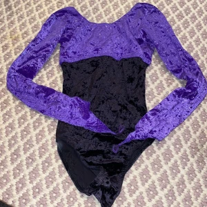 Gymnastikdräkt - Svart och lila glittrig gymnastikdräkt med ring på fingret kan vikas upp om man ej vill använda den men en snygg detalj storlek 140-150