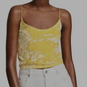 H&M Crushed Velvet Top strl xs - Gul crop top i velvetmaterial. Den är i bra skick och bara använda ett fåtal gånger. Säljer då den inte längre passar mig😊😊 Den är i storlek XS men skulle säga att den passar S också då både tyget och banden är väldigt stretchiga🥰