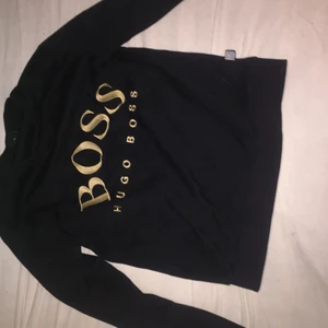 Hugo boss sweatshirt - Hej! Jag säljer nu min Guld svarta Hugo boss sweatshirt som är i ny skick. Den är i storlek XS men passar perfekt om du har storlek S också. Har haft den i några månader nu och säljer den för den inte längre passar mig. 