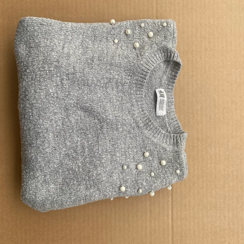 Tröjan är från H&M. Materialet är stickat med en fin ljusgrå  färg. Har använt denna tröja ett par gånger och den är i bra skick. Den luddar inte och behåller pärlorna trotts tvättar. . Tröjor & Koftor.