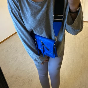 Don Donna väska - Säljer min Donna Donna väska som aldrig är använda och prislappen är kvar. Den blåa färgen är otroligt snygg och passar perfekt nu till sommaren. Det tjocka bandet gör väskan extra snygg och detaljerna. Väskan kostade 400kr.  Man kan självklart byta ut bandet också.🤩