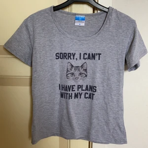 T-shirt med tryck - Grå T-shirt med trycket ”Sorry I Can’t I have plans with my cat”. Strl M men väldigt liten i storlek så passar XS/S.