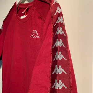 Röd Kappa T-shirt  - Röd kappa t-shirt som tyvärr inte kommer till användning. Är i storlek Xl men jag som vanligt vis använder s har haft denna som oversized T-shirt utan problem. Skulle säga att den är lite mer en L annars.