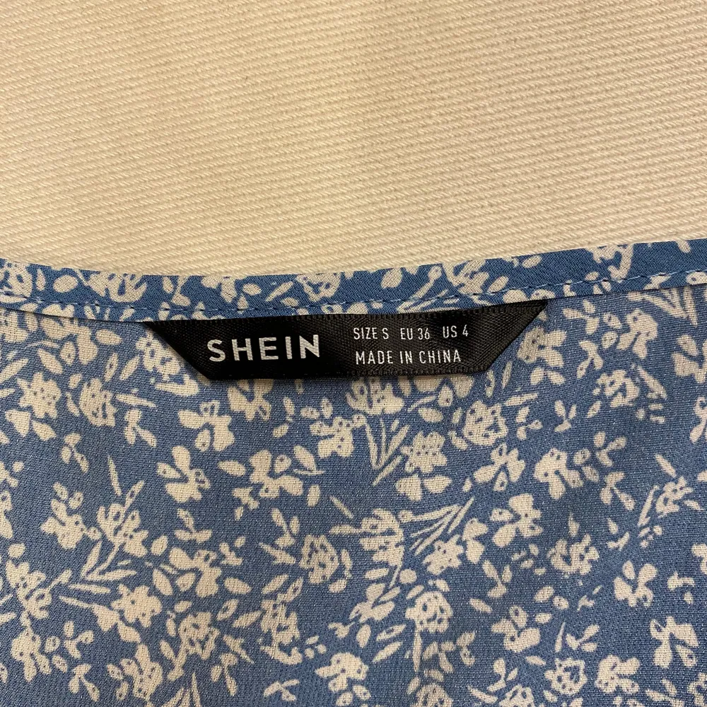 Säljer blå klänning med blommor på som passar perfekt till sommaren från Shein. Köptes i Juni 2021 men bara använts en gång. Därför att jag inte gillade den längre när jag fick den men tänkte inte på det förens jag hade tvättat den och då kunde jag inte skicka tillbaka den. Nypris var 109kr och säljer den för 50kr+frakt. Säljer billigt eftersom jag köpte lång tid sen. Storleken är S. De första två bilderna är lånade från hemsidan och den sista är min men har inga andra bilder med den.. Klänningar.
