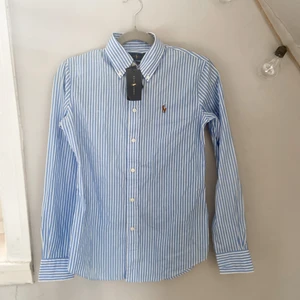Skjorta från Ralph Lauren - Oanvänd skjorta från Ralph Lauren. Lapparna kvar. Storlek 36.  Köparen står för frakt. 