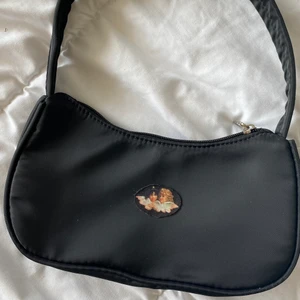Handväska ängel 👼🏼  - Jätte söt svart shoulder bag med två änglar. Ej använd. Frakt på 62 kr tillkommer 👼🏼🖤