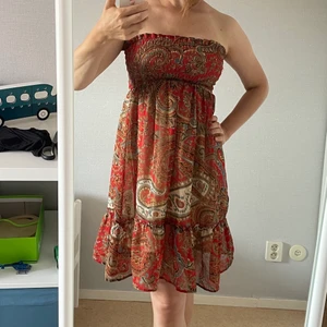 Klänning boho style - Elastisk resår runt bröstet, därför passar till storlekar XS-M. Kan även användas som kjol. I fint skick. Längden 77 cm