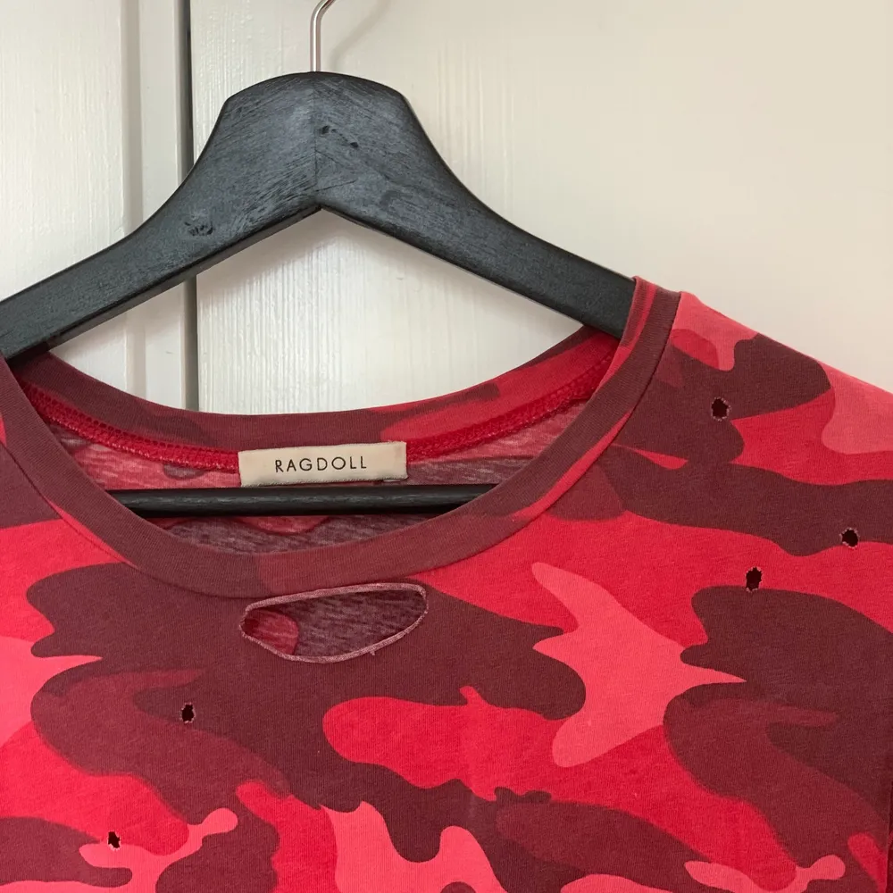 Röd hålig camo t-shirt från Ragdoll LA. Köpt för 800 kr och bara använd ett fåtal gånger. Snygg till jeans o kjol. . T-shirts.