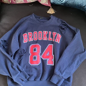 BROOKLYN tröja - Säljer denna tröja då den bara tar plats i garderoben. Den är använd men ej märkbart så. Den är trasig, men köpt så från butik. (Hund i hemmet)