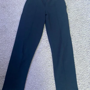 Mjuka Gina byxor - Jättesjuka och härliga byxor från Gina Tricot som liknar kostymbyxor. De är mörkblåa med detaljer fram med ränder. Jättestretchiga i materialet så passar xs-s.