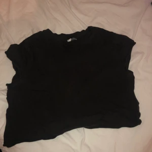 En svart t-shirt - En svart cropped t-shirt ifrån hm i str S. Köparen står för frakten.