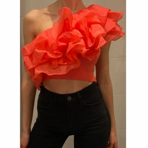 Topp med volang  - Somrig topp i stickat med volanger i korallfärg.                      Ps: Ta gärna en titt på mina andra annonser då jag kan samfrakta flera köp <3
