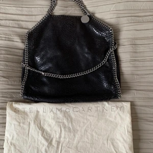 Stella McCartney falabella - Stella McCartney/ Ormskinnsmönstrad/Svart/Falabella. Inköpt på Vestiaire för ett år sedan. Några fläckar inuti väskan från läppstift (se sista bilden). Dustbag medföljer. Köpare står för frakt!