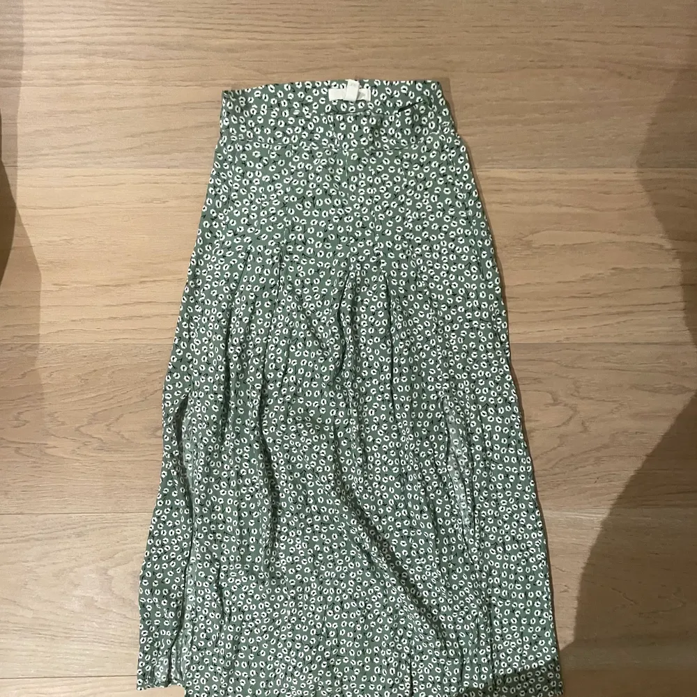 Säljer denna supersöta kjol jag köpte på h&m i somras! Nästan oanvänd och är som ny! Den är grön med vita blommor med två slitsar på sidorna 💗. Kjolar.