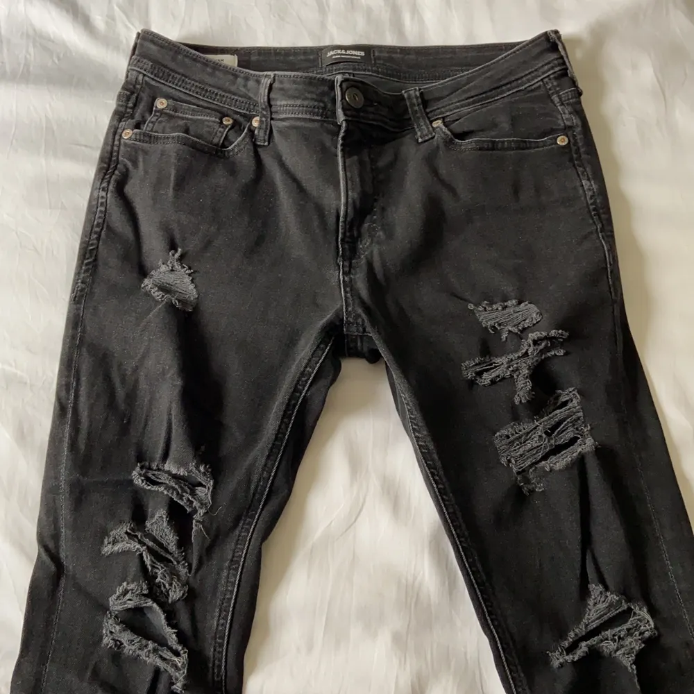 Svarta slitna jeans från Jack&Jones. Det är strl. 31”30. Jag är 175cm och de sitter bra i längden men är för tighta. Jeansen är använda men i bra skick. Bor i Norrköping och kan mötas upp, annars står köparen för frakten. Priset kan diskuteras . Jeans & Byxor.