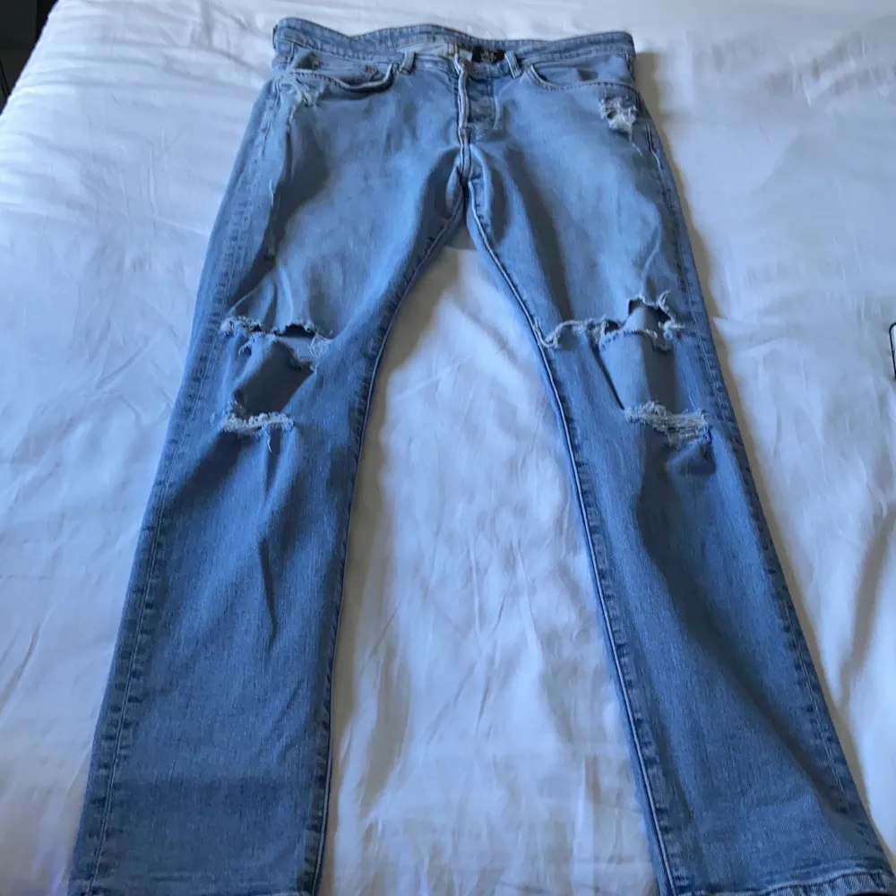 Ljusblå slitna jeans i storlek 34”32. Jag är 175cm och jeansen sitter bra i längden men är för tighta. Det har gått sönder men sytts igen vid rumpan, det är dock inget som syns eftersom det är långt bak. Bor i Norrköping och kan mötas upp, annars står köparen för frakten. Pris kan diskuteras!. Jeans & Byxor.