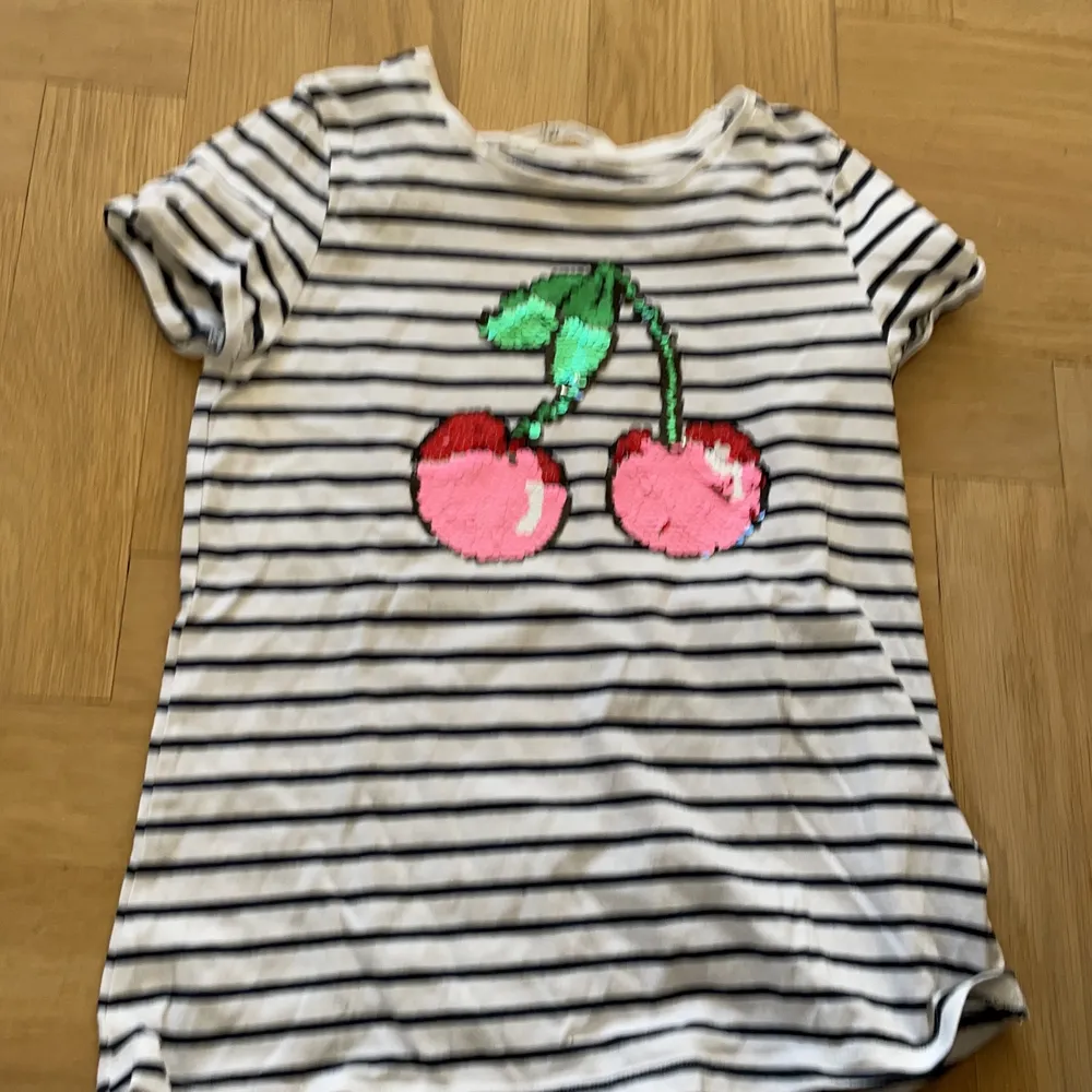 En randig tröja med en frukt  i mitten 🍇. T-shirts.