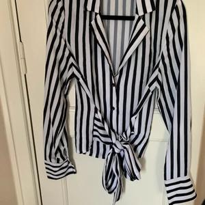 Randig blus med knytdetalj - Randig blus med knytdetalj i midjan fram eller baktill. Använd ett fåtal gånger endast. Hojta till om du vill se fler bilder!