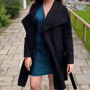 Svart kappa - Fin svart kappa Bälte i samma materiel medföljer Väldigt elegant och perfekt för ’utgång’ Passar alla möjliga outfits Ficka på varsin sida Längd ungefär till knäna Använd skick - Fin skick (som på bilden) Passar XS-M Kan skickas mot frakt, fraktpriset står i nästa steg 📦  Alla betalningar sker tryggt via Swish. 🤝  Inga returer, plagget säljs i befintlig skick enligt bild och beskrivning. ❌ 