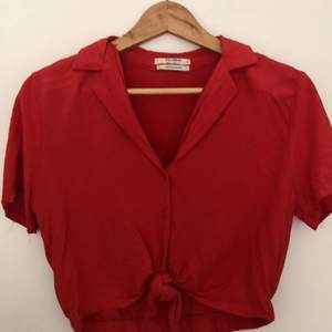 Röd cropped skjorta i stl S. Från pull&bear. Knytning i mitten, knappar och krage. 