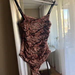 Flerfärgad bodysuit  - Använt 1 gång. Är i fint skick. Axelbanden är justerbara 