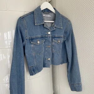 Jeansjacka - Croppad jeansjacka från NA-KD med tryck på ryggen. Storlek 36 🤍