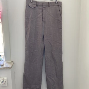 Snygg kostymbyxa  - Rosa/grå aktiga kostymbyxor.  Tyvärr saknas storlek men jag är 180 och på mig passar längden bra. Typ storlek 42 skulle jag uppskatta. Använda väldigt få gånger. 