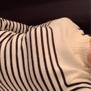 Randig stickad tröja - Superfin och skön mjuk stickad tröja med lite högre krage och knappar på ens axeln. Vet varken märke eller storlek men skulle säga att de är storlek XS/S💙 Fint skick utan några hål eller fläckar!💙 Säljer då jag inte använder den💙