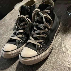 Blåa höga Converse  - Ett par blåa Converse som är höga och är väl använda men är ändå i ett bra skick och smörerna kan även tvättad ifall de ser lite  smutsiga ut. De är äkta Converse. 