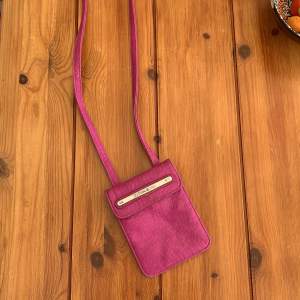 En smidig, liten rosa väska med två fack. Funkar bra till att ha nycklar,fickpengar eller en mindre telefon i! 