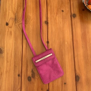 Rosa Björn Borg plånboksväska - En smidig, liten rosa väska med två fack. Funkar bra till att ha nycklar,fickpengar eller en mindre telefon i! 