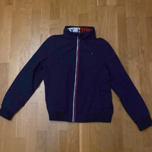 Tommy Hilfiger Jacka  - Tunn Tommy Hilfiger Jacka med uppfällbar luva. Mycket bra skick.