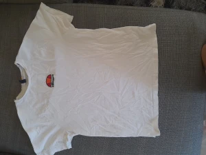 Vit Ellesse T-shirt! - En vit Ellesse T-Shirt med text! Använd ett fåtal gånger och är i bra skick! 