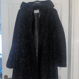 Pälsjacka  - Pälsjacka med luva som går ner till halva låret. I mycket gott skick 