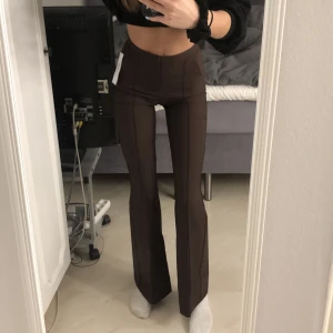 Kostymbyxor Gina Tricot  - Säljer ett par helt nya kostymbyxor ifrån Gina. Prislapp finns kvar. Storlek XXS men skulle säga att den även passar en XS. Ordinarie pris 499:- mitt pris 260:- Färgen är mörkbrun vilket jag tycker är väldigt snyggt till hösten! 🍁