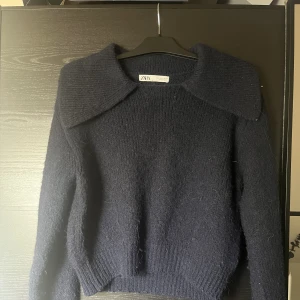 Stickad tröja - Mörkblå stickad tröja med krage. Har blivit lite nopprig.