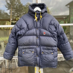 Fjällräven expedition Down Lite Navy Jacket - Hej, säljer en väldigt populär marinblå Fjällräven vinterjacka i bra skick. Storlek XXXS men kan passa allt från 160-180 cm beroende på storleksperferens. Finns en liten defekt, bild i DM. Nypris över 7000kr. Pris kan diskuteras. Hör av dig vid frågor. 