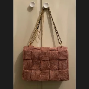Väska - Virkad väska i fin "dusty pink" färg, virkad på dubbeltråd. Väskan stängs igen med ett magnetiskt knäppe.  MATERIAL: 1 tråd akryl+ 1 tråd bomull  MÅTT: längd:27cm, höjd:19,5cm & djup:5,5cm  OBS! Katter finns i hushållet!