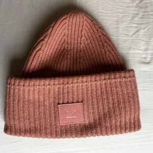 Acne Studios Pansy Mössa Rosa - Klassika Pansy från Acne Studios i Dusty pink (tror jag färger heter).  100% ull.  Använd en säsong.   700kr, finns att hämta centralt i Stockholm alt skickas spårbart á 60kr. 