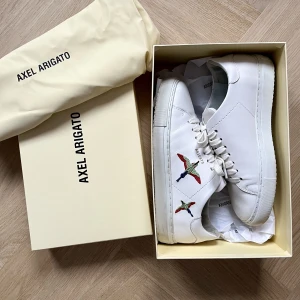 Axel Arigato  - Axel arigato skor i storlek 38, knappt använda (Max 3 gånger) så dem är i fint skick, utan skador eller defekter. Köpta på NK i Stockholm för 2500kr. Skorna finns inte längre på deras hemsida. 🤗😍(hör av dig till mig för fler bilder💓)