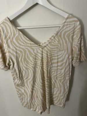 Beige leopard t-shirt - Säljer en beige t-shirt med leopardmönster i storlek M från Gina Gina tricot, endast använd vid ett tillfälle. 