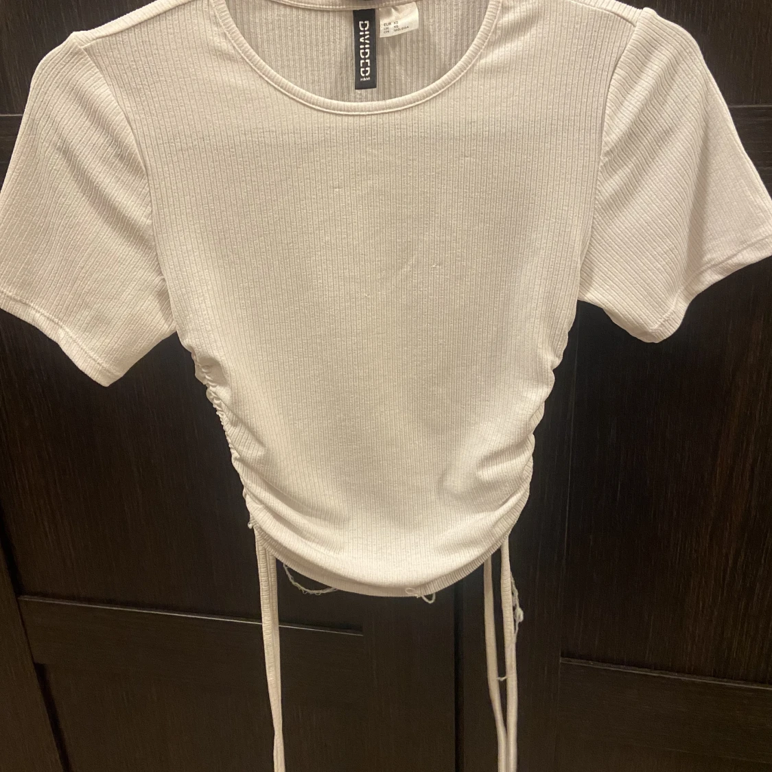 Vit ribbad t-shirt med snören man kan dra åt