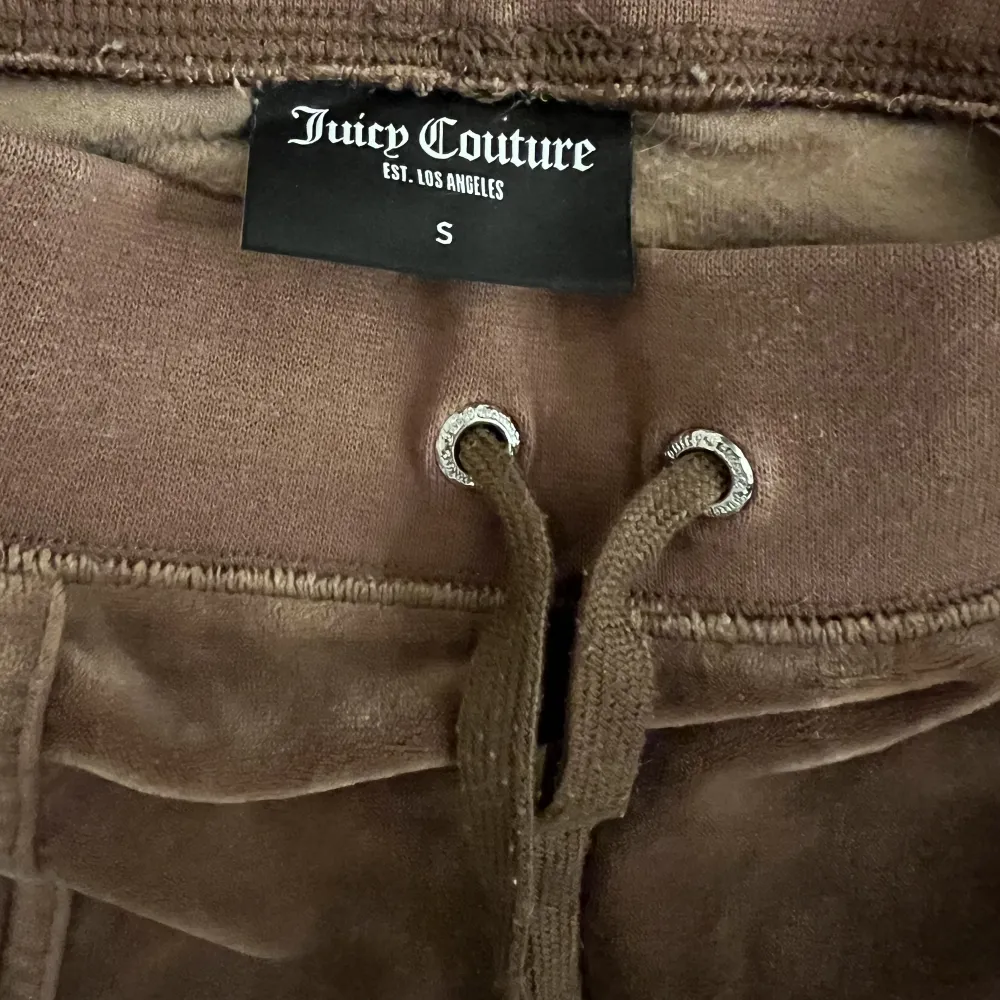 Säljer Juicy Couture byxa i modellen Del Ray Classic. Storlek S. Färg Bronze. Ena metallbiten till snöret har lossnat men är fastlimmad igen. . Jeans & Byxor.
