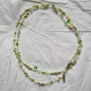 Grönt halsband med massa olika pärlor och kristaller. Den är ca 120cm i omkrets
