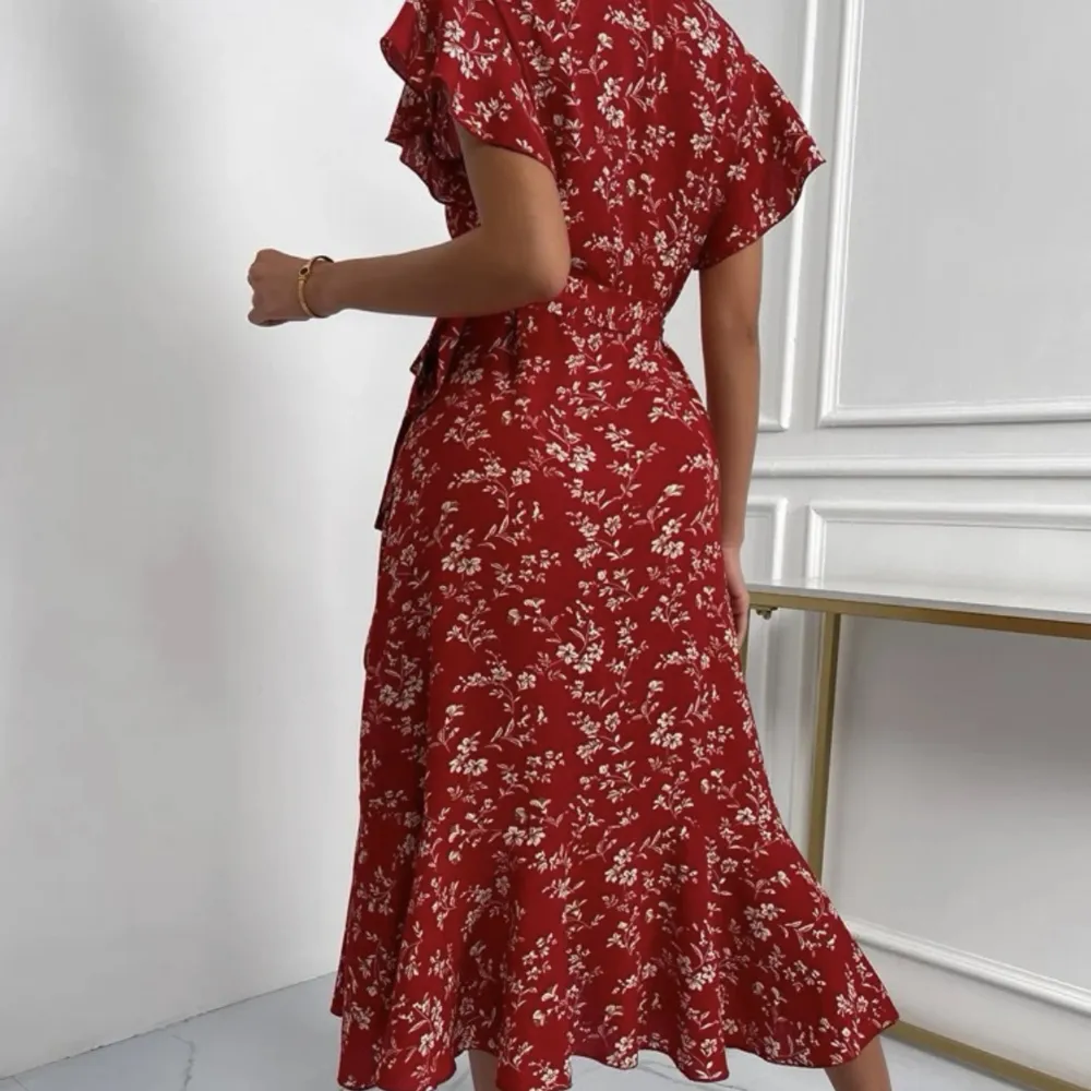 Jättefin röd blommig långklänning. De är en wrap klänning så du anpassar den för din kropp och knyter på sidan. Provad och använd 1 gång.. Klänningar.
