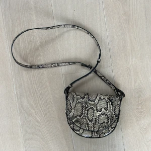 H&M axelremsväska  - Ormskinnsmönstrad axelremsväska Som ny.  Nypris: 199 kr