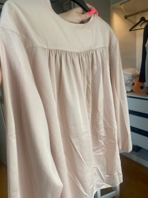 Ljusrosa blus - Ljusrosa/beige blus, vid modell med en ficka på.