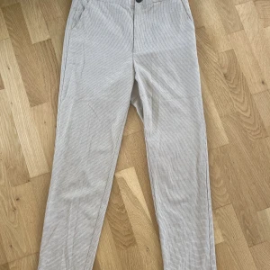 Ljusbeiga kostymbyxor  - Raka kostymbyxor med en perfekt färg för hösten. Ljusbeiga och brunt nätmönster som är ett stilrent mönster. Väldigt mjuka för att vara kostymbyxor men det förstör inte passformen. Skulle säga att de passar en 36 också 