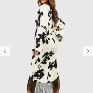 BLOMMIG MIDIKLÄNNING MED OMLOTT OCH FRANSAR - Säljes då den inte var min stil. Storlek 38, passar S och M.  Produkt: Omlottklänning Design: Blommigt Material: Vävt material Längd: Midi Ärm: Långärmad 100 % polyester. Modellen har på sig storlek 38.