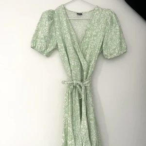 Blommig klänning - Supersöt blommig klänning med puffärmar och ett snöre att knyta runt midjan! 